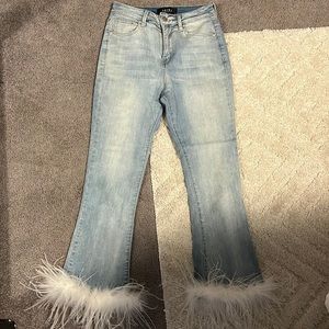 Akira jeans with white feathers around the ankles